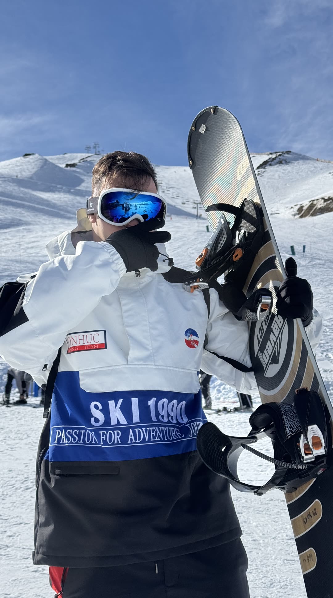 Sheik com a prancha de snowboard no alto da montanha